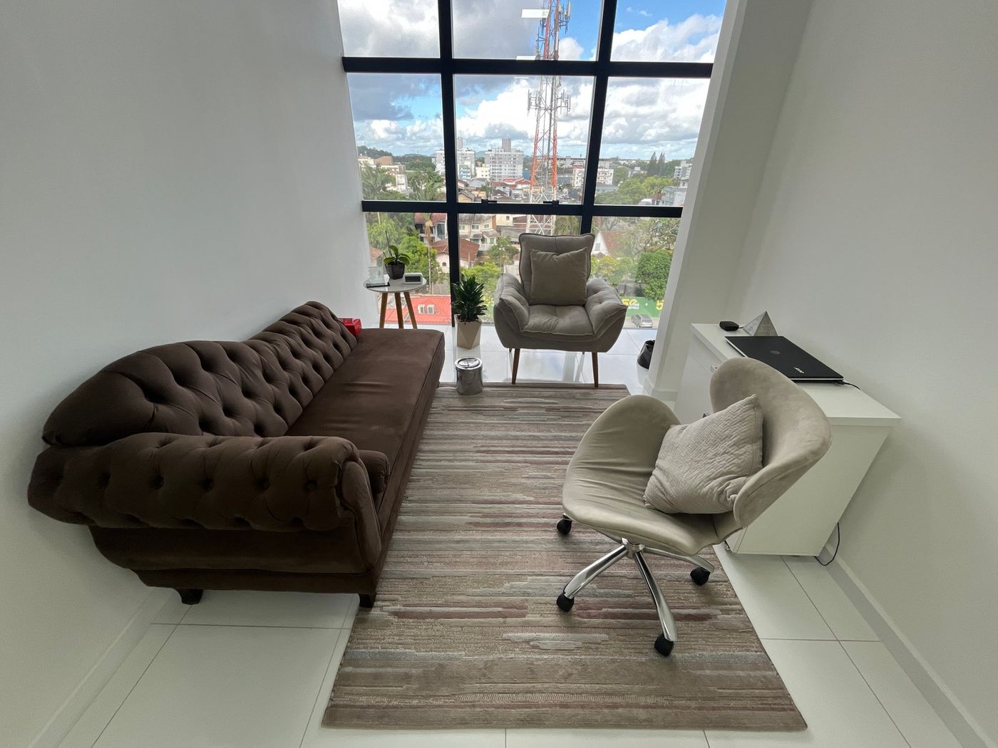 Sala de atendimento com janela ampla e vista da cidade